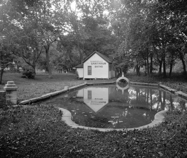 View of a sanitarium bath near a pond at a sulphur spring. The waters were advertised to aid kidney and stomach troubles.