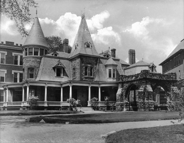Exterior of Lauralton Hall, founded in 1905 by the Sisters of Mercy. The large building exhibits a porch and an ivy-covered stone shelter with arches on each side.