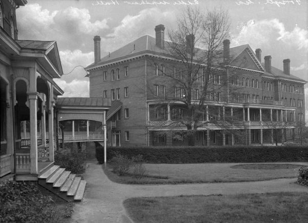 Exterior of Addie Upshaw Hall, completed in 1904. The building was erected on the campus of Bessie Tift College, founded in 1849.  On the far left, a set of stairs leads to the porch of Ponder Hall, built in 1883. A covered walkway connects the two buildings.