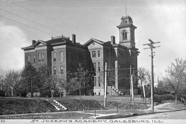 Exterior of Saint Joseph's Academy, founded and constructed in 1879.  A fence surrounds the school grounds where a staircase leads to the main entrance. Caption reads: "St. Joseph's Academy, Galesburg, Ill."