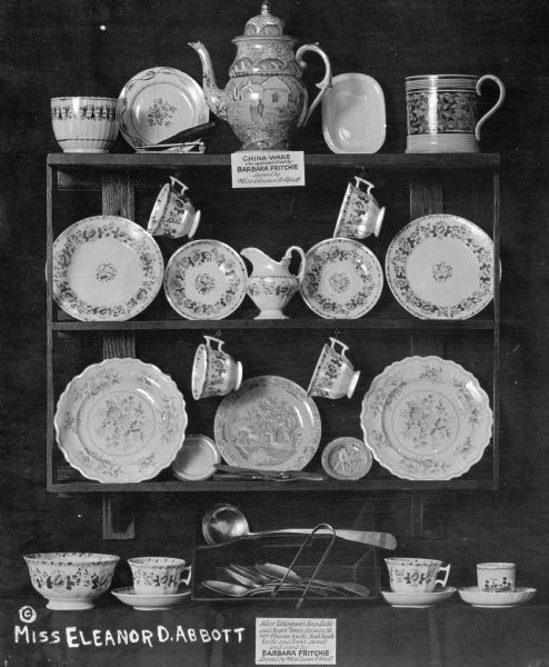 Display containing china and silver owned by Barbara Fritchie (1766-1862), a heroine who defied General Stonewall Jackson and the invading troops. Sign at top reads: "China-Ware Owned and Used by Barbara Fritchie Loaned by Miss Eleanor D. Abbott." Sign at bottom reads: "Silver Tablespoons, Soup Ladle and Sugar Tongs, German Silver Cheese Knif, Buck Handle Knie fna Forks owned and used by Barbara Fritchie Loaned by Miss Eleanor D. Abbott."