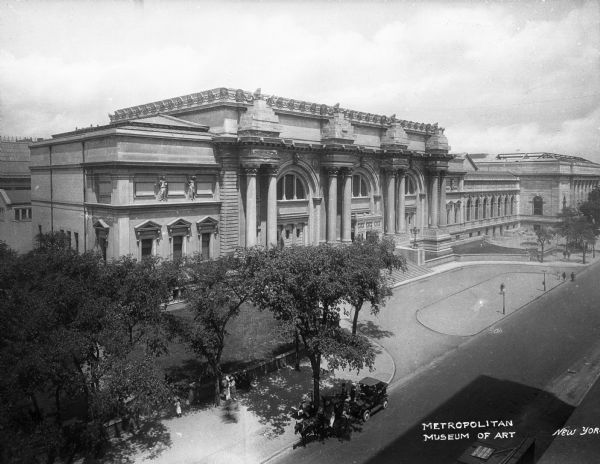Elevated view of the Metropolitan Museum of Art, founded in 1870. The building, completed in 1880, features neoclassical architecture. In front of the museum, an automobile and a horse-drawn carriage are parked. Caption reads: "Metropolitan Museum of Art."