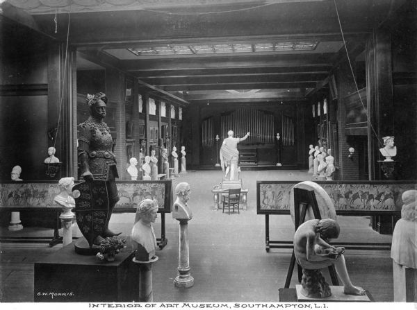 Interior of Parrish Art Museum, built in 1898. The gallery features many paintings, portraits and sculptures. On the far wall, a pipe organ can be seen. Caption reads: "Interior of Art Museum, Southampton, L.I."