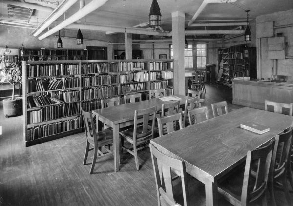 Interior of the library at Amalgamated Clothing Workers' Cooperative Village, designed by the architects Springsteen & Goldhammer and completed in 1930. Tables and chairs surround bookshelves in the library.