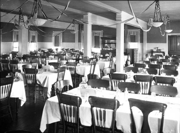 Interior of Biscayne Dining Room. Chairs and tables fill the room and the ceilings are adorned with streamers and flags.