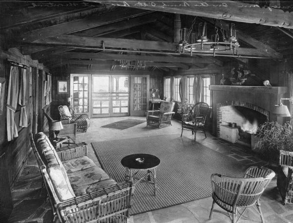 Interior of the living room at Gurney's Inn, built in 1926 by W. J. and Maude Gurney.  The room is filled with furniture that surrounds a fireplace on the right.
