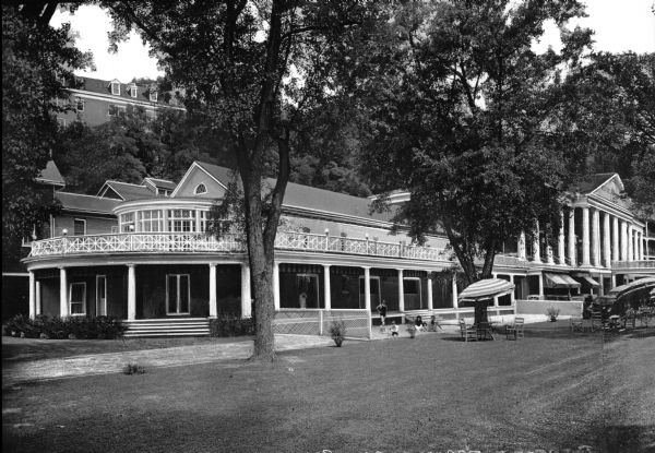 View across lawn, with a driveway on the left leading to the Bedford Springs Resort. Children and adults are relaxing outdoors. The hotel was built in 1806.
