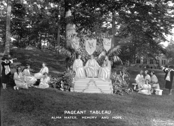 View of an outdoor pageant tableau at the College of Mount Saint Vincent, founded in 1847 by the Sisters of Charity of New York. Students stand in a wooded area, acting in costumes. Caption reads: "Pageant Tableau, Alma Mater, Memory and Hope."