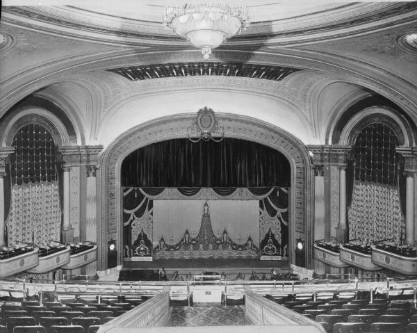Interior of Loew's Metropolitan Theatre. The view, taken from the mezzanine, features the stage, seating, and side balconies and a chandelier hangs from the ornate ceiling. The theater was designed by Thomas Lamb and opened on September 15, 1918.