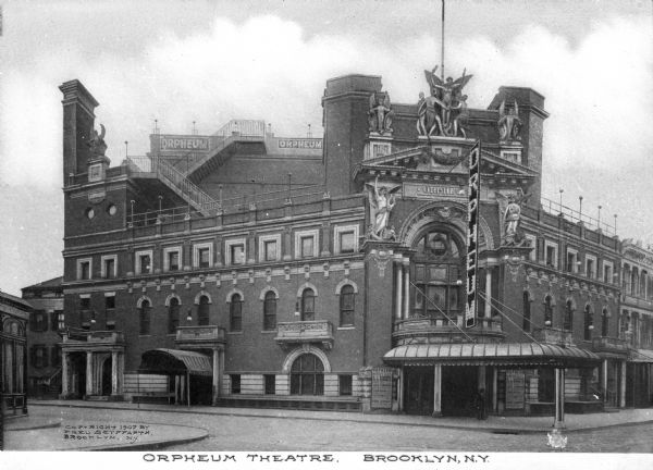 Exterior of the Orpheum Theatre, which opened in 1900. Designed by Frank Freeman in the Beaux-Arts style, the facade features sculptures, a marquee, and balconies. On the corner, a large, arched window with a balcony can be seen above a sidewalk awning. Caption reads: "Orpheum theatre, Brooklyn, N.Y."