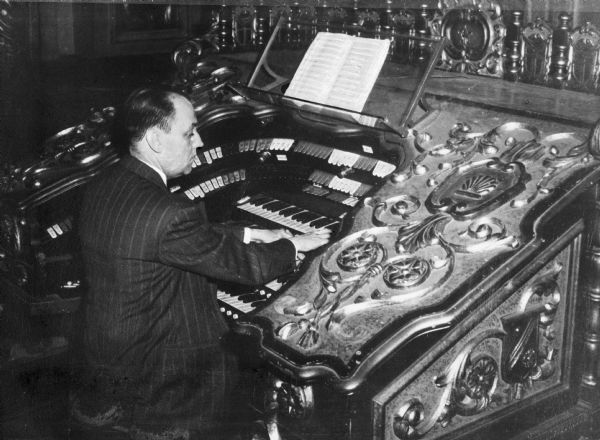 View of Dr. Bedell (1909-1974), American composer and organist, playing a Wurlitzer organ.