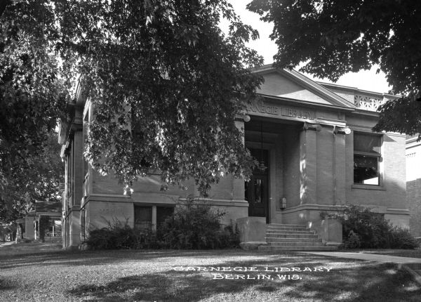 A walkway leads to the stairs at Carnegie Library's main entrance. The library was built in 1903 after the city received a Carnegie grant. Caption reads: "Carnegie Library, Berlin, Wis."