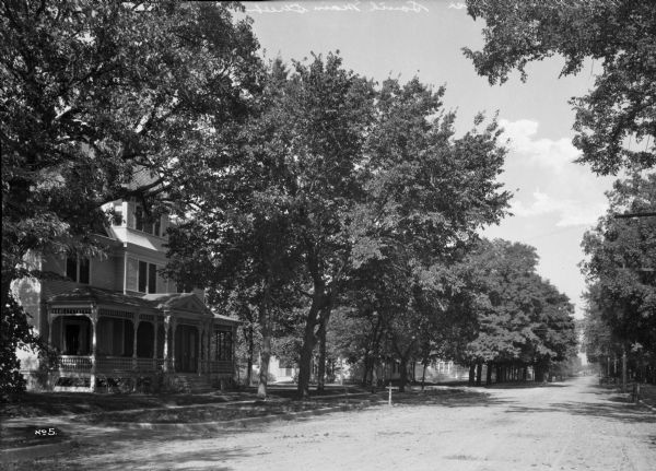 View down South Main Street. Houses are on the left, and trees line the street.