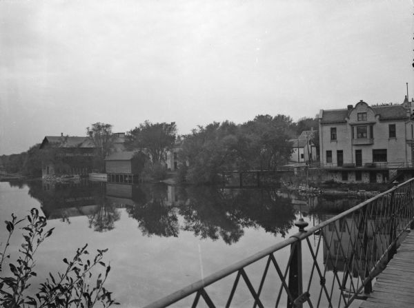 View of the west bank of the Rock River from a bridge. The view includes the manufacturing plants of Jefferson Woolen Mills, incorporated April 2, 1856.