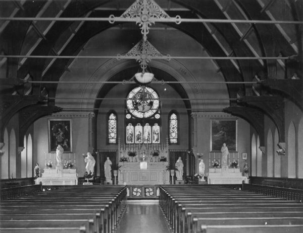 Interior of the chapel at Saint Clara Academy, built in 1852. Founded by Father Samuel Mazzuchelli, the academy's chapel features large paintings and sculptures flanking a central altar accented by stained glass windows.
