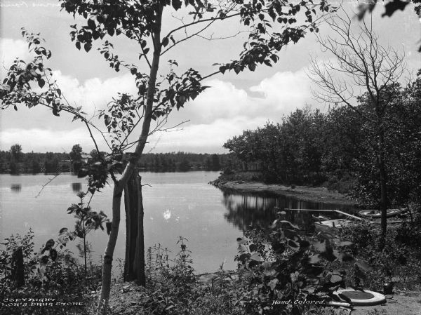 View of the Wisconsin River at River Pine Sanitarium, which opened in 1906. Boats are near a small dock to the right.