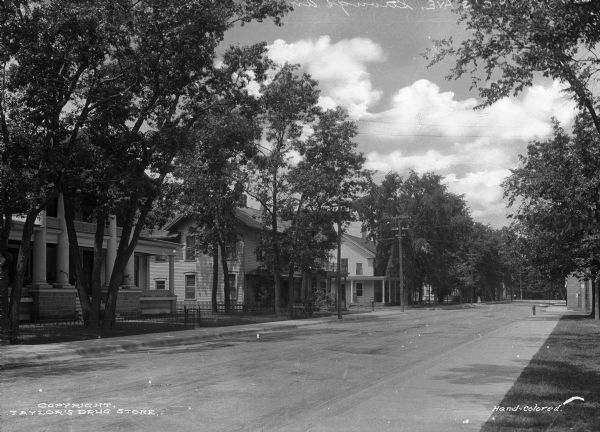 View from right toward the left side of Strong's Avenue, a residential area. A house with large columns is on the left along with other residences.