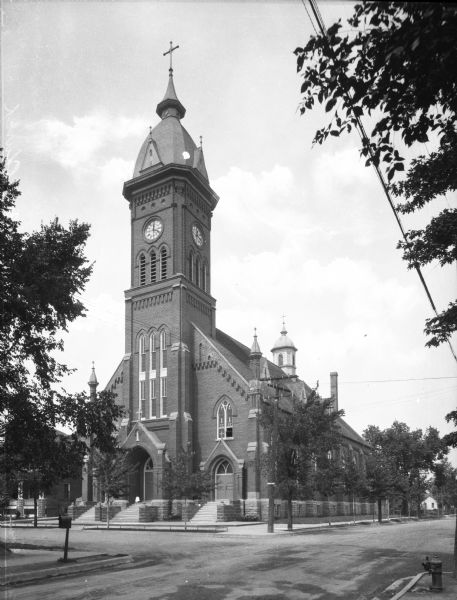 Exterior of Saint Peter's Catholic Church, dedicated in 1897 and constructed by Joseph Hutter. The church is located on Fourth Avenue and features a central clock and belfry over its main entrance.