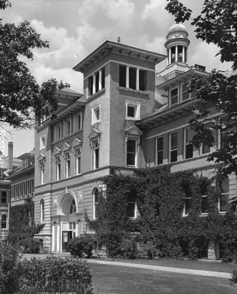 Exterior of the State Normal School at Stevens Point, which opened in 1894. The main entrance flanked by columns and a central cupola can be seen, along with a row of pedimented windows.