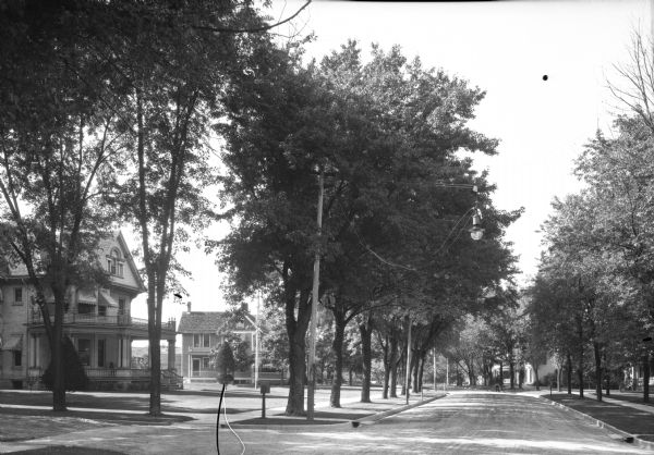 View down North Washington Street. The road is lined with residences, most with porches and balconies. A traffic light hangs from a wire at the intersection.