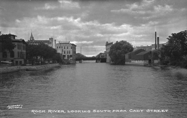 View of Rock River, looking south from Caly Street. The view features a bridge and downtown buildings. Caption reads: "Rock River Looking South from Cady Street."