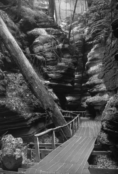 A wooden bridge leads to a rock formation.