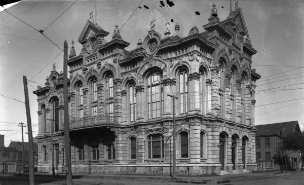 Exterior of Harmony Hall, a building with extensive decorative architectural forms. The building stands amidst dwellings in a residential area; it was constructed in 1880 by Nicholas Clayton.