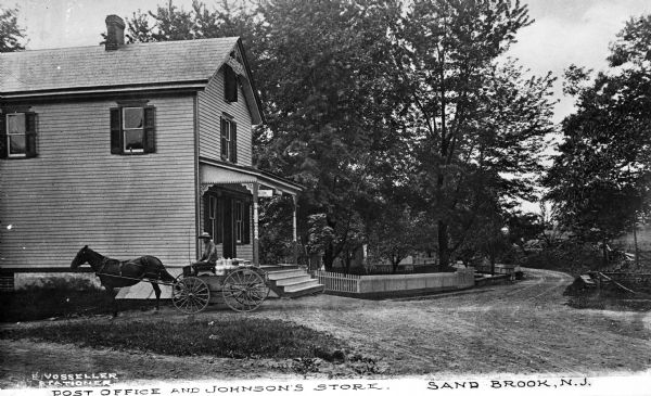 View of the post office and Johnson's Store, located in a rural setting.  A man carries goods in a horse-drawn wagon.  Published by E. Vosseller Stationer.