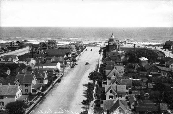Elevated view of Engleside Avenue leading to the ocean.  Automobiles drive in the street near dwellings.