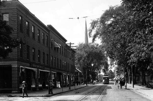 View down Main Street featuring stores and a trolley car.