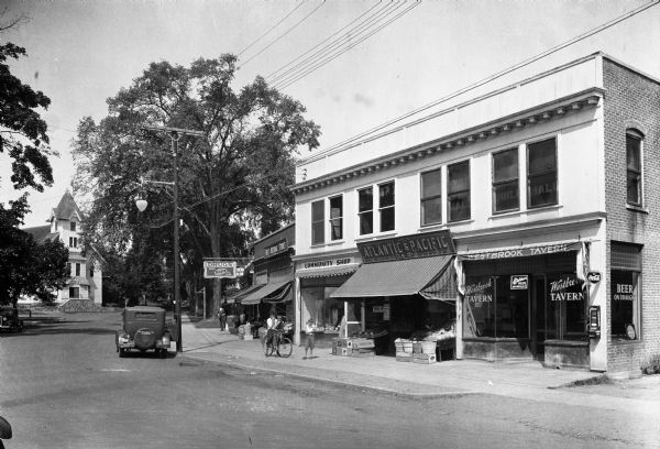 View of the business section of town featuring Westbrook Tavern, The Great Atlantic and Pacific Tea Company, First National Stores, a drug store, and an ice cream parlor.