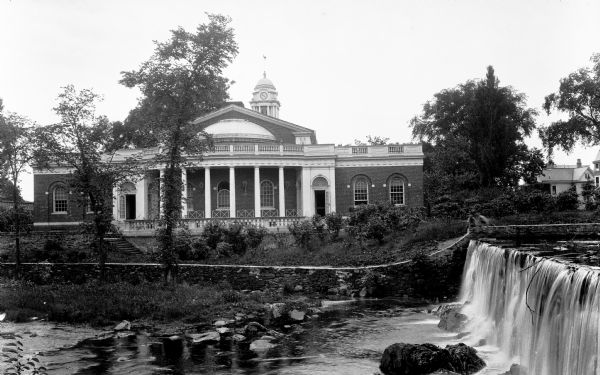 View of Milford City Hall, built in 1916.  A waterfall is visible in the foreground.