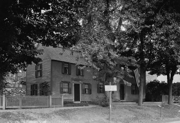 View of a colonial home which became the Daughters of the American Revolution Chapter House in 1894.  Tombstones can be seen to the left behind the home.