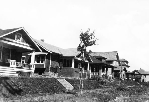 View of a residential area, featuring homes with stairs leading to porches.
