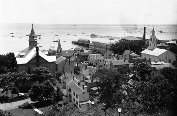 Elevated view of the city showing churches, the bay, and boats.