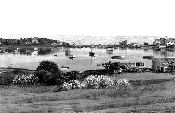 General view of Wychmere Harbor, filled with small boats.   Houses can be seen on the shore.