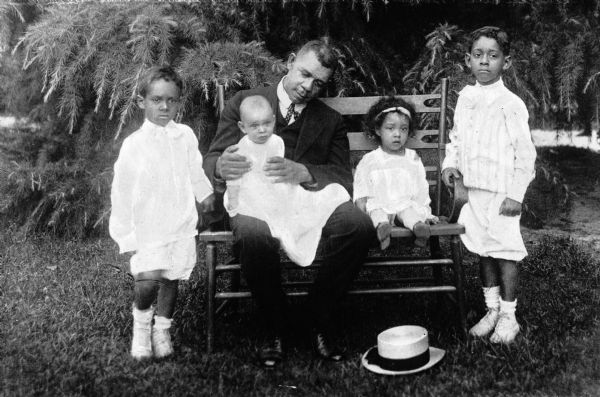 Photographic portrait of Booker T. Washington (1856-1915) and his four grandchildren.