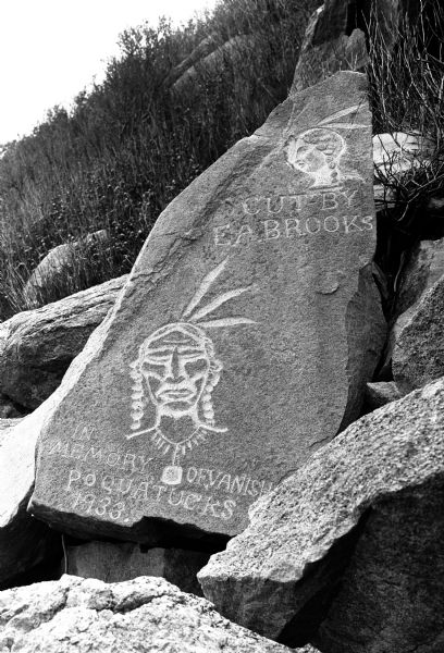 Memorial rock carving cut by E. A. Brooks.  In addition to a portrait of an Indian man and woman, the memorial reads "In Memory of Vanished Poquatucks. 1933."