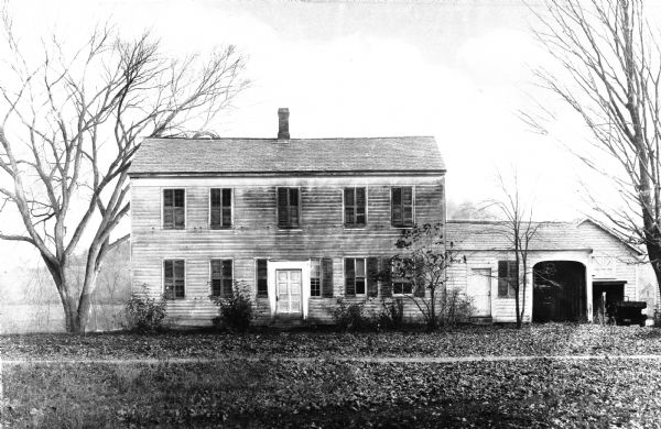 Exterior of the Horace Greeley house, built between 1852-1854. The two-story house features a central chimney and an attached garage.