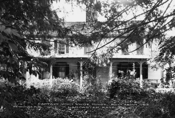 Exterior of Captain John White House, built about 1707, a modest home overgrown with greenery.  Published by H. W. Newcomb.