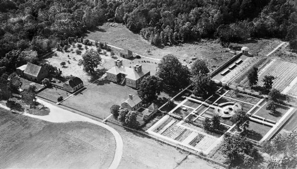 Aerial view of Stratford Hall, the ancestral home of the family of Robert E. Lee, built in the Georgian style in 1725.  To the right of the house, the kitchen and the restored gardens can be seen.  On the left stands the coach house and stable.
