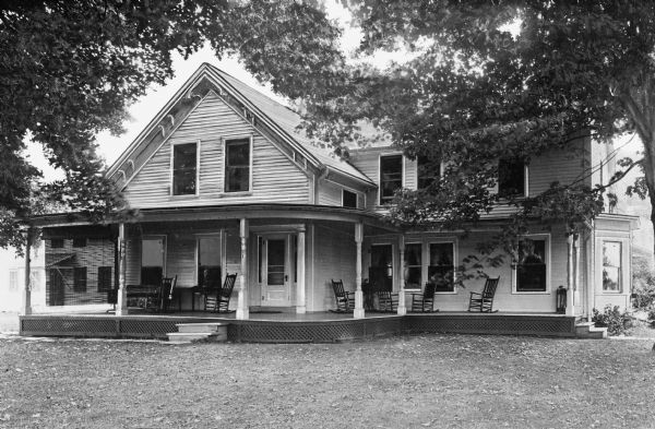 Exterior view of West View Farmhouse, built in 1870.  Rocking chairs can be seen on the house's porch.