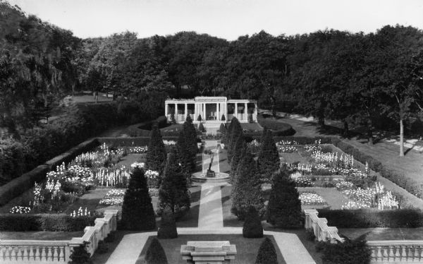View of an elaborate garden with a fountain and sculpture at the Walhall Estate.