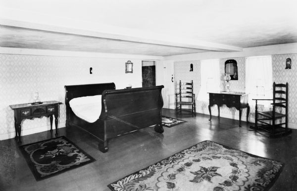 Interior view of Longfellow's Wayside Inn, which opened in 1716.  The spacious Longfellow Room features an elaborate bed and ornate floor rugs.