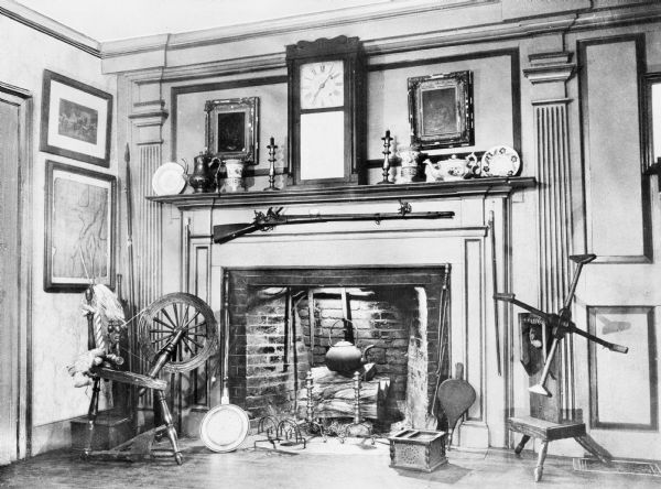 Interior of Judson House, built by Captain David Judson in 1750.  The living room features a fireplace with elaborate woodwork and decorations.