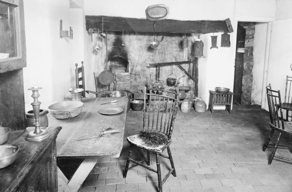 Interior of Washington's headquarters, built by Isaac Potts and occupied by George Washington in 1777. The kitchen features a table, chairs, utensils, and an oven.