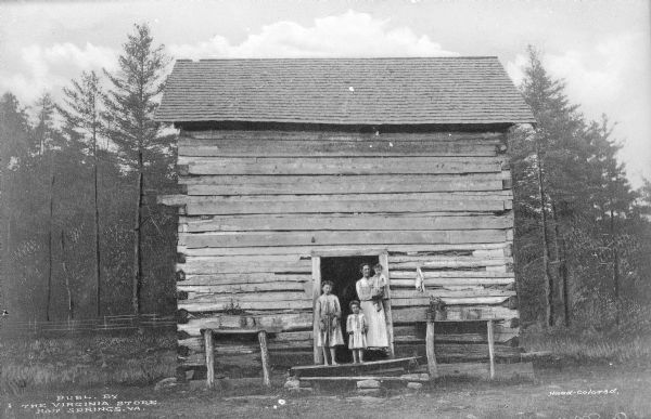 View of a mother and three children standing on the front step of their mountain cabin. Published by the Virginia Store.