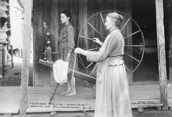 A woman uses a spinning wheel outdoors while a barefoot girl stands on a porch behind her. Published by Jos. Milner & Son.