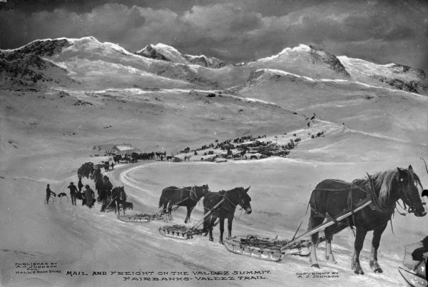 View downhill of a mule train with mail and freight in the mountains on the Fairbanks-Valdez Trail. Published by A.J. Johnson and Hall's Book Store.  Copyright by A.J. Johnson.