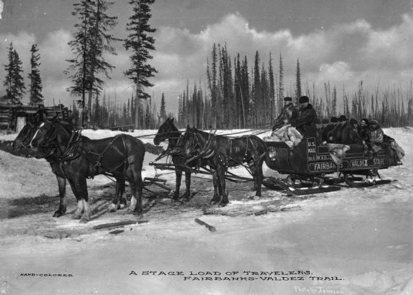 Side view of a stagecoach filled with passengers and labeled, "U.S. Mail, Fairbanks Valdez Stage."